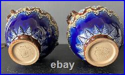 A PAIR OF ANTIQUE DOULTON LAMBETH WARE URNS By Elizabeth Atkins. Height 14cm